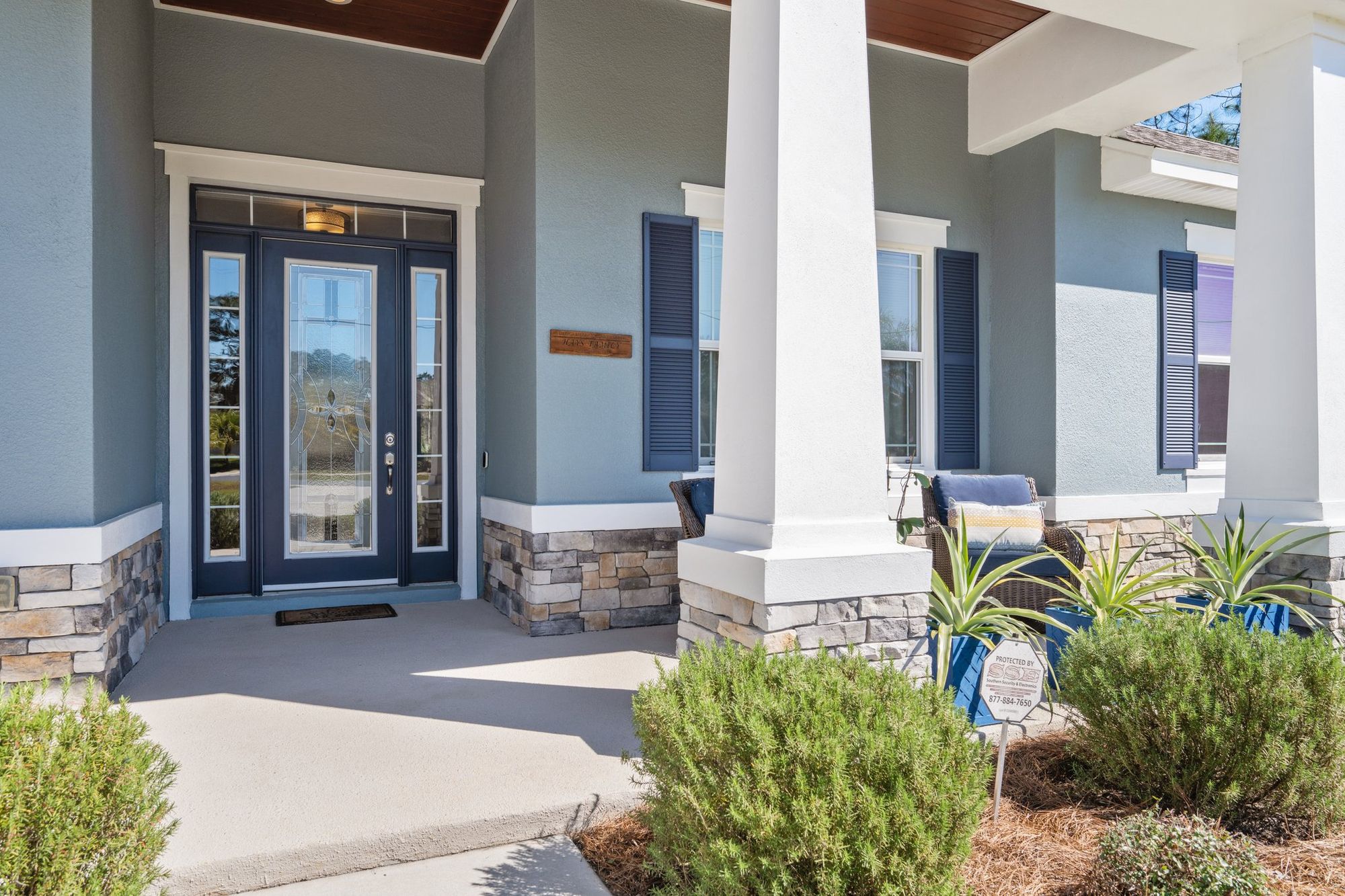Front door with decorative glass and stone columns