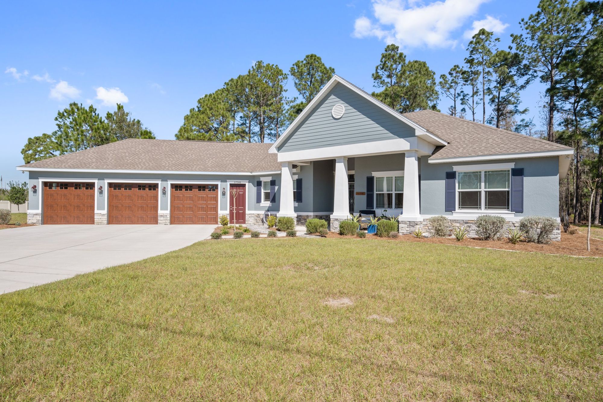 Front of the home with a three-car garage and columned porch
