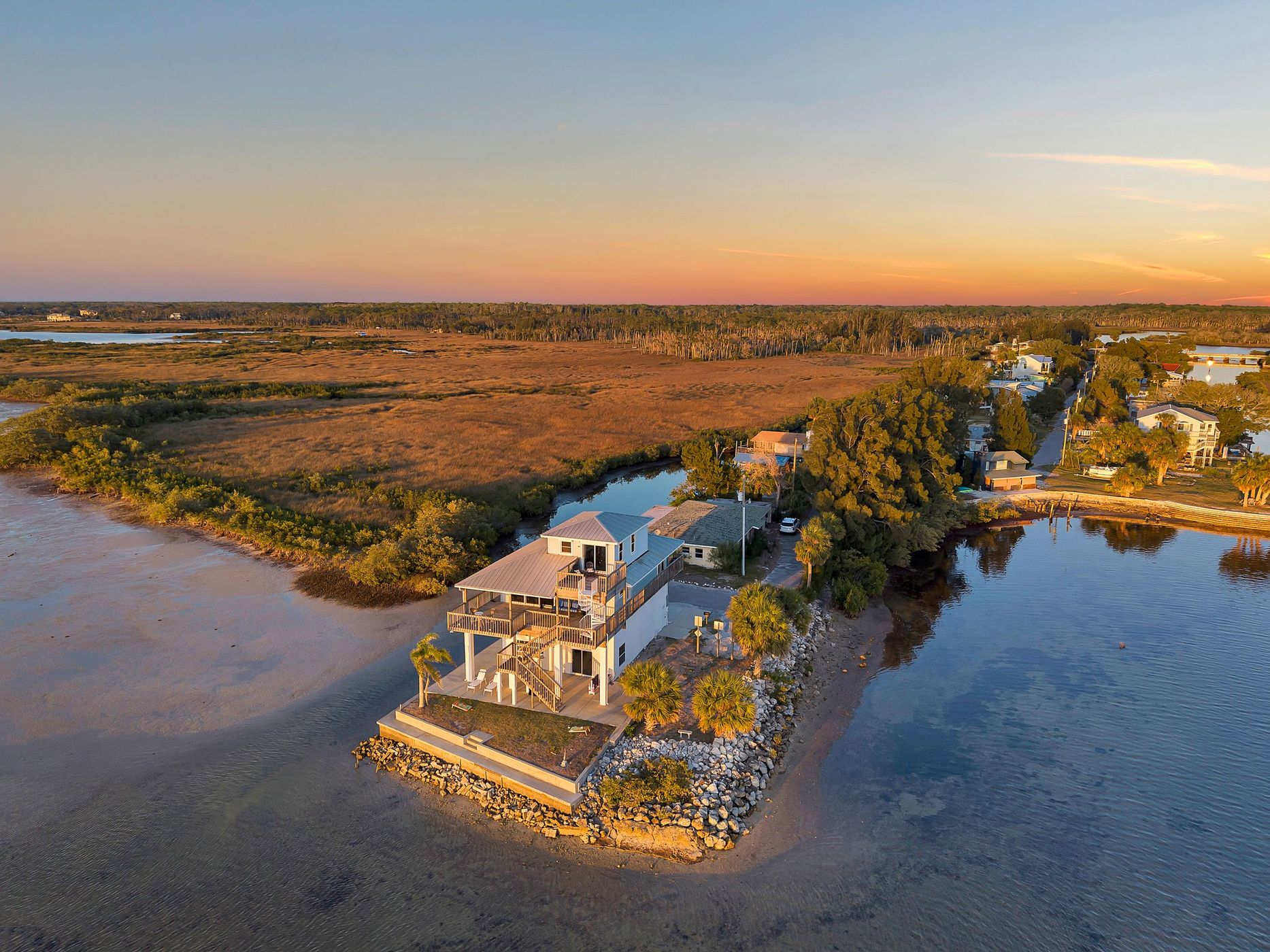 Wider aerial of the home, marsh, and neighboring water